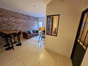 - un salon avec un mur en briques et une table dans l'établissement Appartement cosy centre ville proche chantiers navals, calanques, plages, à La Ciotat 5 autres photos