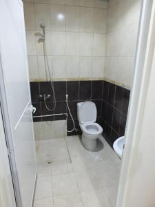 a bathroom with a toilet and a shower at B&B Hostel in Dubai