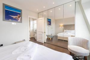 a white bedroom with a bed and a chair at Luxury 2 bed in front of Museums in London