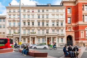 a group of people sitting on a bench in front of a building at Luxury 2 bed in front of Museums in London