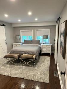 a bedroom with a bed with two night stands and two windows at Waterfront Cottage in Muskoka in Severn