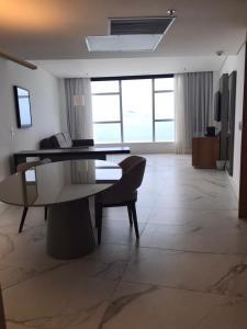 sala de estar con mesa y sofá en Suíte Com Vista pro Mar no Hotel Nacional en Río de Janeiro