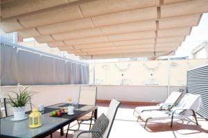 a patio with tables and chairs and a wooden ceiling at Feelathome Poblenou Beach Apartments in Barcelona