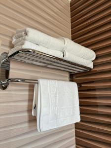 a towel rack with white towels on a wall at CELINE CONFORT N. D. COCEA in Bucharest