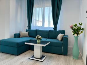 Sofá azul en la sala de estar con mesa en CELINE CONFORT N. D. COCEA en Bucarest