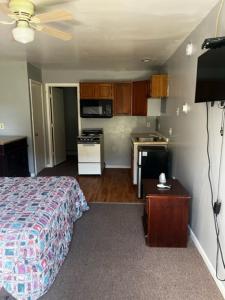 a small bedroom with a bed and a kitchen at Grand Howell Inn in Howell