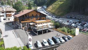 ein großes Gebäude mit Autos auf einem Parkplatz in der Unterkunft Tyrol Living & Cafe in Welschnofen