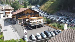 a large building with cars parked in a parking lot at Tyrol Living & Cafe in Nova Levante