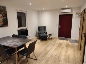 een woonkamer met een tafel en stoelen en een deur bij Seepark 13 in Goch