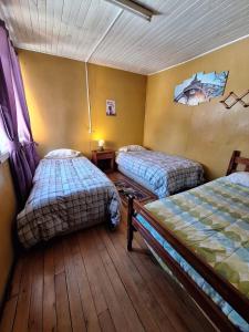 HOSTAL VALDIVIA في فالديفيا: غرفة بسريرين في غرفة