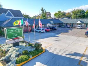 una señal para una posada comunitaria en un estacionamiento en Courtesy Inn Downtown Eugene, en Eugene