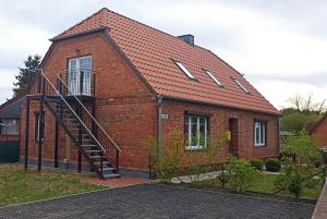 a brick house with a staircase on the side of it at Gemütliche Wohnung am Wald 
