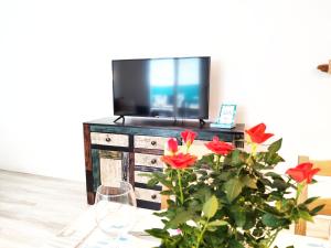 una mesa con un jarrón de flores y un televisor en Altea en el casco antiguo con patio interior, en Altea