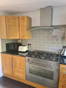 a kitchen with a stainless steel stove and wooden cabinets at Guest house room 1 in Haverfordwest