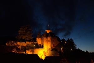 un gran castillo iluminado por la noche en Ferienwohnung Heimbach Burgblick, en Heimbach