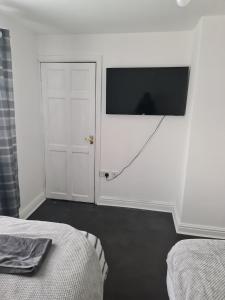a bedroom with a flat screen tv on the wall at Guest house room 1 in Haverfordwest