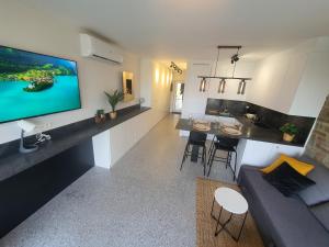 a living room and kitchen with a large flat screen tv at À Durbuy in Durbuy