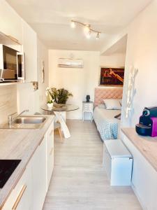 uma cozinha com um lavatório e uma mesa num quarto em Maison du bonheur em Cagnes-sur-Mer