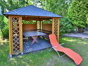 a wooden gazebo with a picnic table and two chairs at Comfortable holiday home on a private property Kolobrzeg in Kołobrzeg