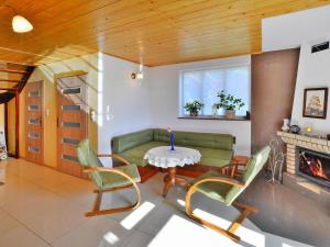 a living room with a table and chairs and a couch at Lakeside holiday home, private garden in Dąbrowica