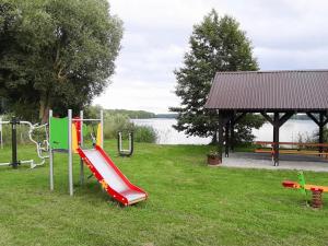 a park with a playground with a slide at Lakeside holiday home, private garden in Dąbrowica