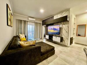 a living room with a couch and a flat screen tv at DeeLops Apt 304 @Sarona City in Gaborone