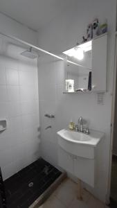 a white bathroom with a sink and a mirror at Cavas de Mendoza - Syrah - 3 habitaciones - Frente al Shopping in Guaymallen