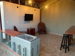Habitación con mesa y TV en la pared. en Alojamiento céntrico, en Cobija