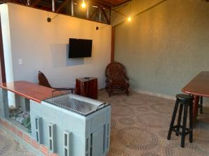 a room with a table and a tv on a wall at Alojamiento céntrico in Cobija