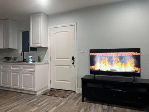 a kitchen with a television with a fire on the wall at Guest house near UCD Med. Center in Sacramento
