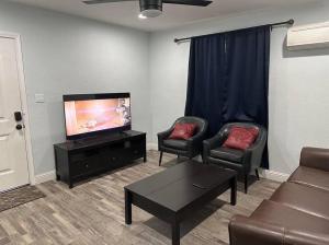 a living room with two chairs and a flat screen tv at Guest house near UCD Med. Center in Sacramento