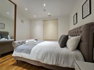 a bedroom with a large bed and a couch at Cozy Flat close to central London in London