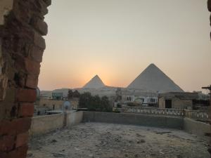 widok na piramidy gizy o zachodzie słońca w obiekcie Elkhaima motel w mieście Giza