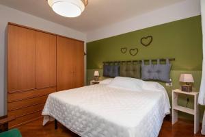 um quarto com uma cama branca e dois corações na parede em Intero appartamento em Carona