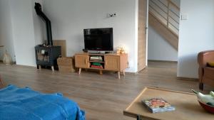 uma sala de estar com uma televisão numa mesa de madeira em Maison du petit p(a)in em Cucq