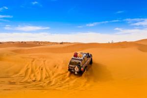 a jeep driving through the sand in the desert at L'Oasis à Tozeur in Tozeur