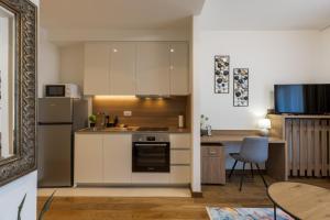a kitchen with white cabinets and a refrigerator and a table at inJoy in Sajmište