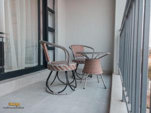 two chairs and a table on a balcony at DeeLops Apt 304 @Sarona City in Gaborone