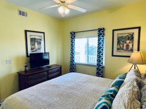 a bedroom with a bed and a flat screen tv at Boca Ciega Resort in St. Petersburg