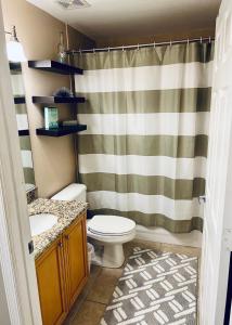 a bathroom with a toilet and a shower curtain at Boca Ciega Resort in St. Petersburg