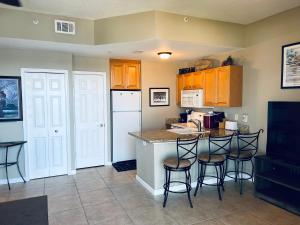 a kitchen with a counter and stools in a room at Boca Ciega Resort in St. Petersburg