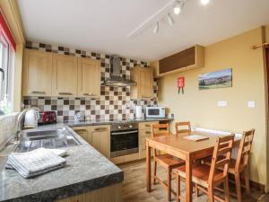 a kitchen with a table and chairs in a kitchen at Edge Hill in Dalry