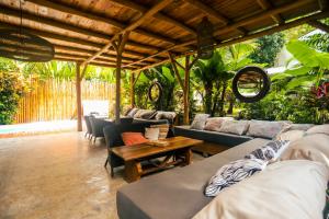 uma sala de estar com sofás e uma mesa em Cabinas Playa Surf Hostel em Santa Teresa