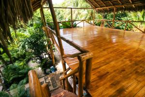 una terraza de madera con una silla de madera en el porche en Cabinas Playa Surf Hostel, en Santa Teresa Beach