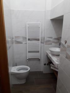 a white bathroom with a toilet and a sink at Bed And Breakfasts LA CASETTA in Terranova di Pollino