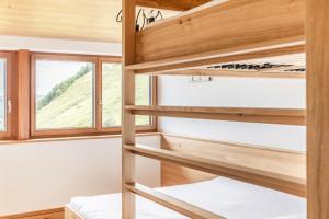 Pokój z drewnianymi łóżkami piętrowymi w małym domku w obiekcie Berg Aparts Faschina - 13 - b42795 w mieście Fontanella