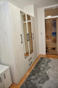 a bathroom with a large wooden cabinet with a mirror at ENA apartman in Kraljevo