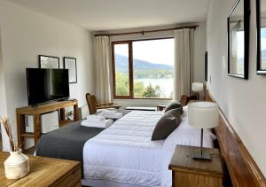 a bedroom with a large bed and a large window at La Balconada by DOT Boutique in Villa Pehuenia