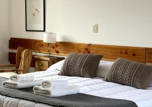 sypialnia z łóżkiem z ręcznikami w obiekcie La Balconada by DOT Boutique w mieście Villa Pehuenia