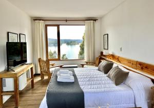 sypialnia z łóżkiem i dużym oknem w obiekcie La Balconada by DOT Boutique w mieście Villa Pehuenia
